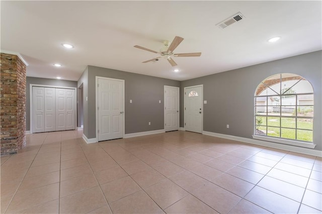 empty room with light tile patterned floors and ceiling fan