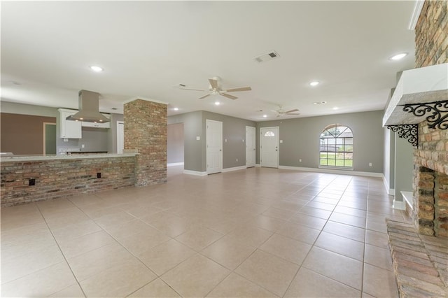 unfurnished living room featuring ceiling fan, a fireplace, and light tile patterned floors