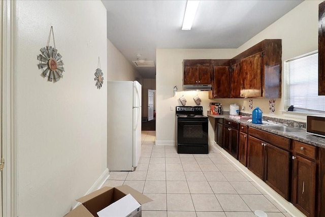 kitchen with dark brown cabinets, white fridge, light tile patterned floors, and black electric range