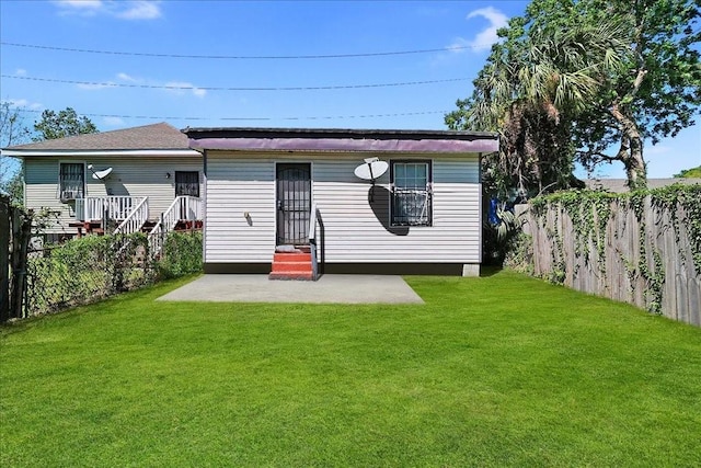 rear view of property featuring a patio area and a yard