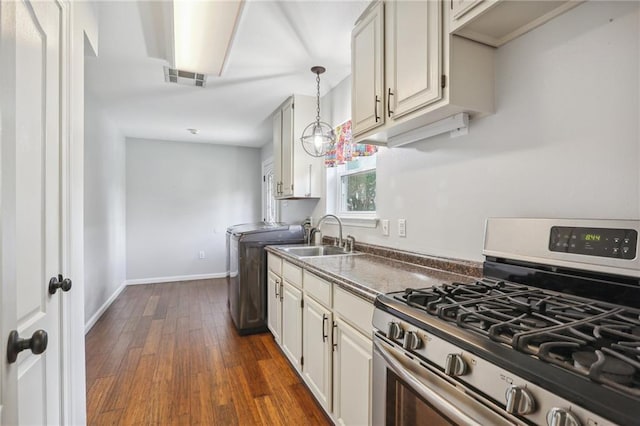 205 Stonehaven Dr, Belle Chasse, LA 70037 - kitchen with dark hardwood / wood-style flooring, stainless steel gas range, sink, washer and dryer, and hanging light fixtures