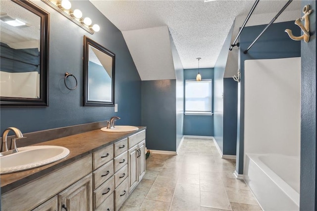 205 Stonehaven Dr, Belle Chasse, LA 70037 - bathroom featuring vanity, a textured ceiling, and vaulted ceiling