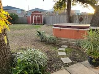 view of yard with a hot tub and a storage unit