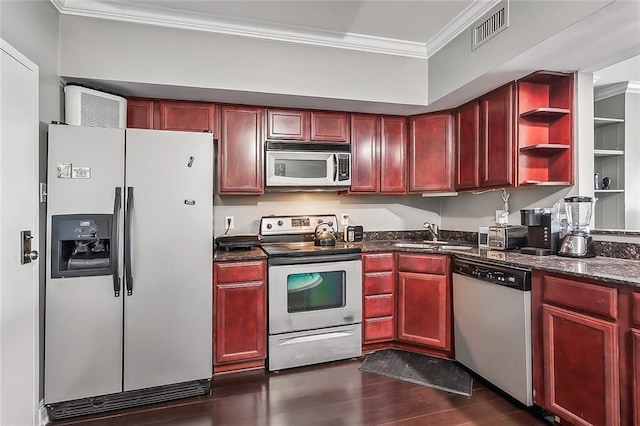 kitchen featuring sink, dark stone counters, crown molding, stainless steel appliances, and dark hardwood / wood-style flooring