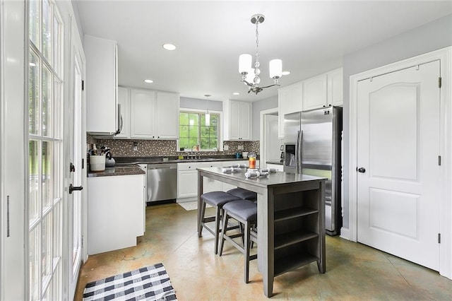 kitchen with appliances with stainless steel finishes, backsplash, sink, and white cabinets