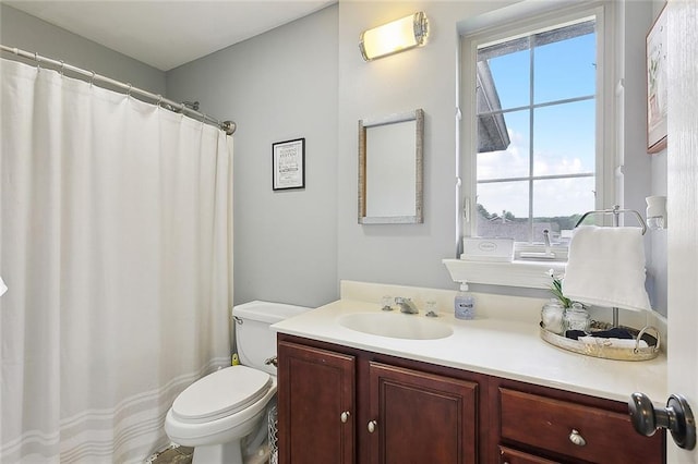 bathroom featuring walk in shower, plenty of natural light, vanity, and toilet