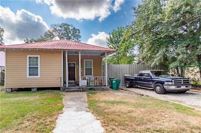 bungalow-style home featuring a front lawn and covered porch