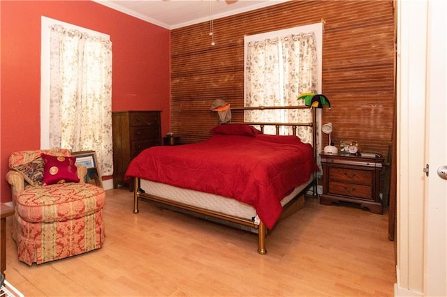 bedroom featuring ornamental molding and wood finished floors