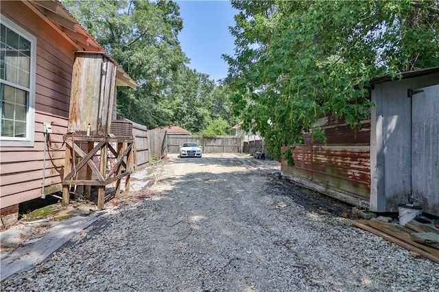 view of yard with driveway and fence