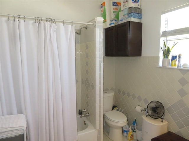 bathroom with tile walls, shower / tub combo with curtain, and toilet