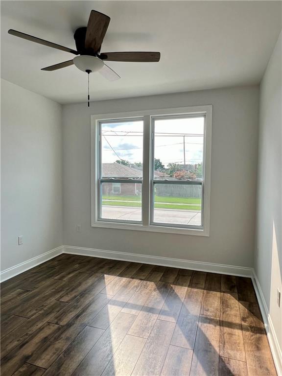 unfurnished room featuring ceiling fan and dark wood-type flooring