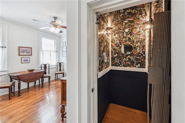 corridor with hardwood / wood-style floors and crown molding