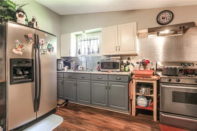 kitchen with gray cabinetry, white cabinets, backsplash, and appliances with stainless steel finishes