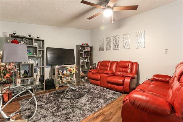 living room with a textured ceiling, hardwood / wood-style flooring, and ceiling fan