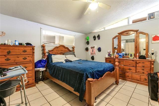 tiled bedroom with a textured ceiling, ceiling fan, and lofted ceiling