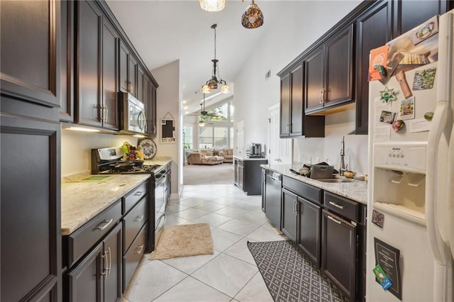 kitchen featuring dark brown cabinetry, hanging light fixtures, light tile patterned floors, and stainless steel appliances