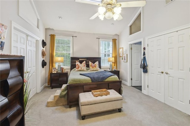 bedroom with ceiling fan, light carpet, and vaulted ceiling