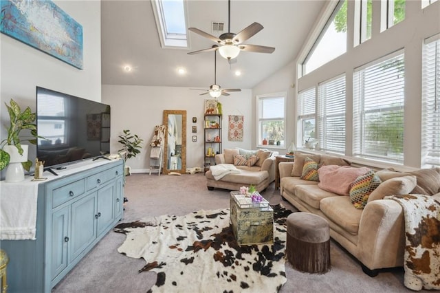 living room with ceiling fan, light colored carpet, high vaulted ceiling, and a skylight