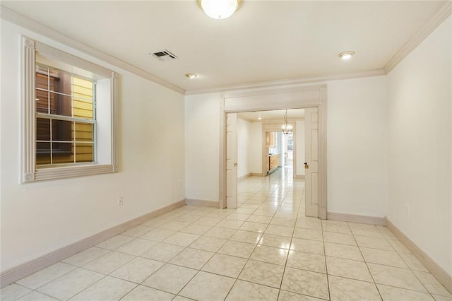 empty room featuring crown molding, light tile patterned floors, and an inviting chandelier