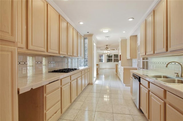 kitchen with light brown cabinets, stainless steel dishwasher, tile counters, and sink