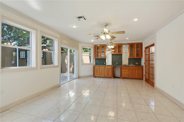 kitchen featuring ceiling fan, light tile patterned flooring, ornamental molding, and backsplash