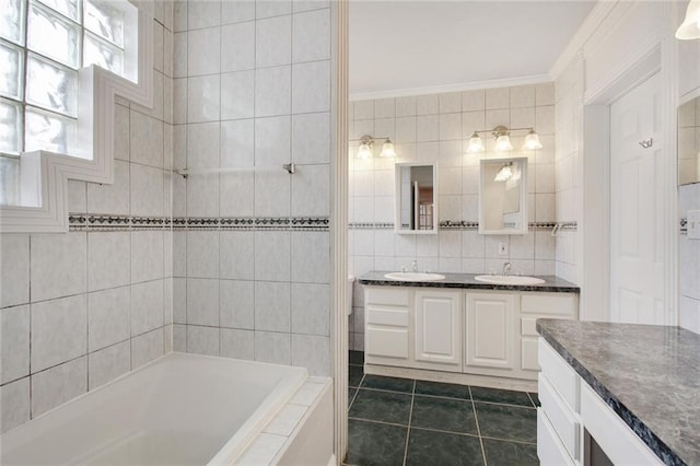 bathroom featuring vanity, tile patterned flooring, a relaxing tiled tub, ornamental molding, and tile walls