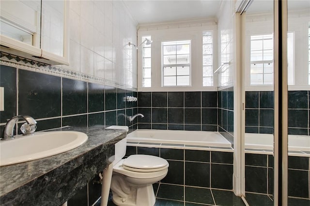 bathroom featuring sink, tile walls, tile patterned flooring, tiled bath, and toilet