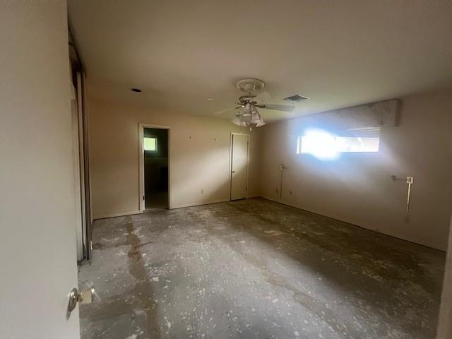 empty room with concrete flooring and ceiling fan