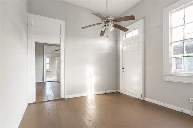 spare room featuring a healthy amount of sunlight, wood-type flooring, and ceiling fan