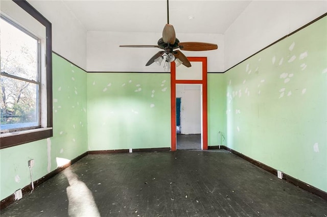 empty room featuring ceiling fan, concrete flooring, and a wealth of natural light