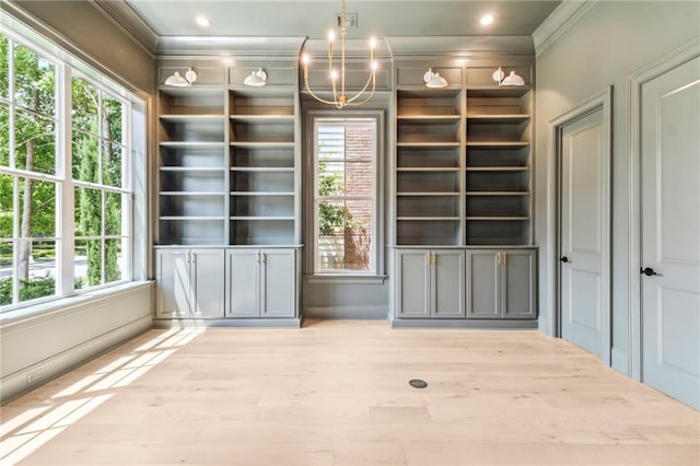 interior space featuring a notable chandelier, light wood-type flooring, and plenty of natural light