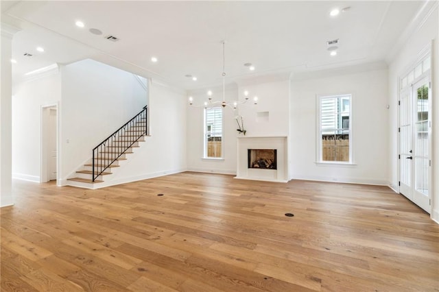 unfurnished living room with light hardwood / wood-style flooring and crown molding