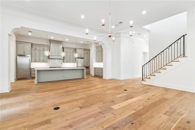 unfurnished living room with crown molding and light wood-type flooring