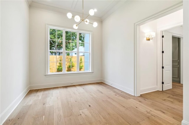 spare room featuring light wood-type flooring, a notable chandelier, and a wealth of natural light