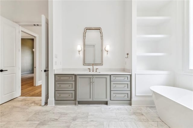 bathroom with vanity, tile patterned flooring, built in shelves, and a washtub