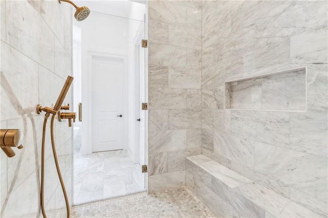 bathroom featuring tiled shower and tile patterned flooring