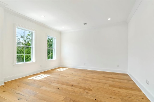 spare room featuring crown molding and light wood-type flooring