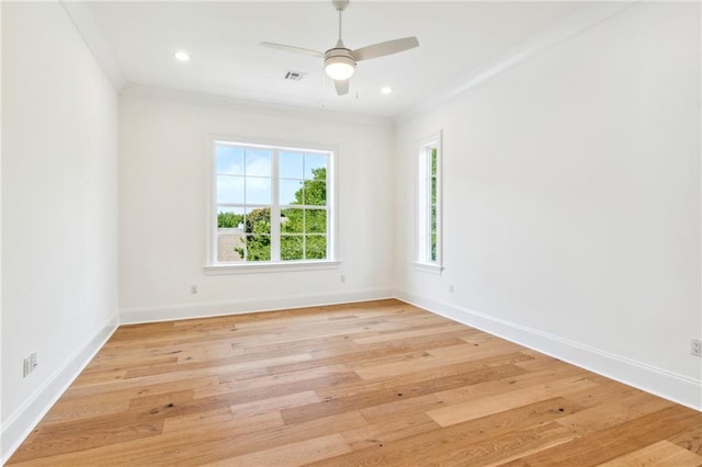 unfurnished room featuring ornamental molding, a wealth of natural light, and light wood-type flooring