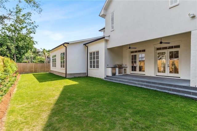 exterior space with french doors, a lawn, and ceiling fan