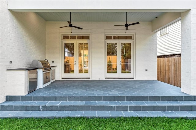 entrance to property featuring a patio, an outdoor kitchen, ceiling fan, and french doors