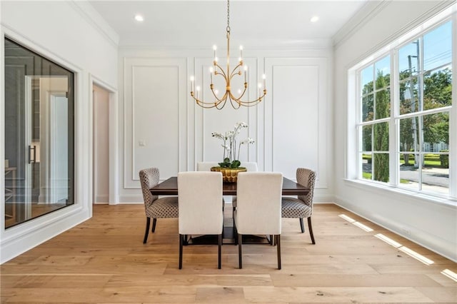 dining space featuring a wealth of natural light, light wood-type flooring, and a chandelier