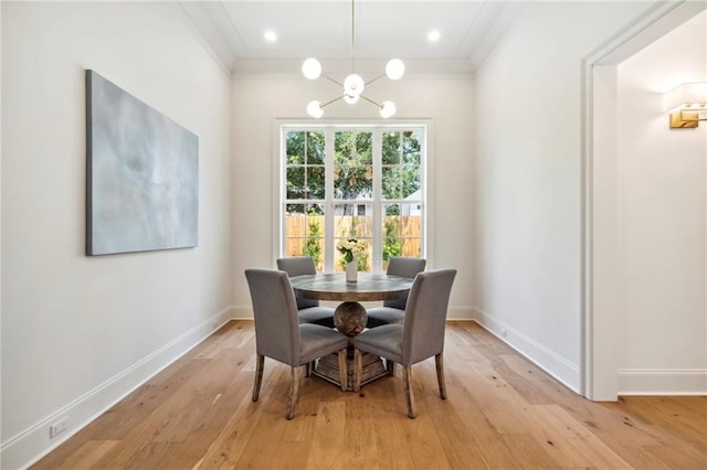 dining space featuring a notable chandelier, crown molding, and light wood-type flooring