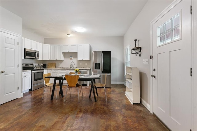 kitchen with appliances with stainless steel finishes, dark wood-type flooring, sink, and white cabinetry