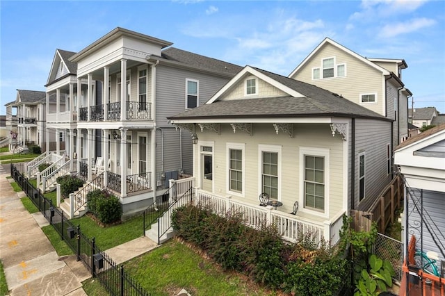 rear view of property featuring covered porch and a balcony