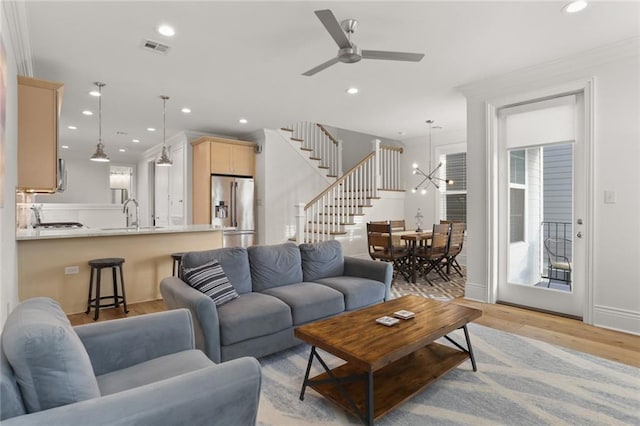 living area with stairway, visible vents, light wood finished floors, and recessed lighting