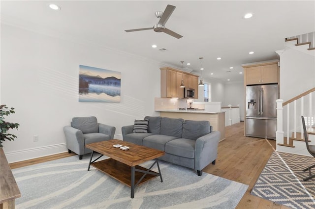 living area with light wood-style flooring, stairway, baseboards, and recessed lighting