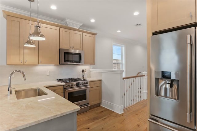 kitchen featuring appliances with stainless steel finishes, light stone countertops, crown molding, pendant lighting, and a sink