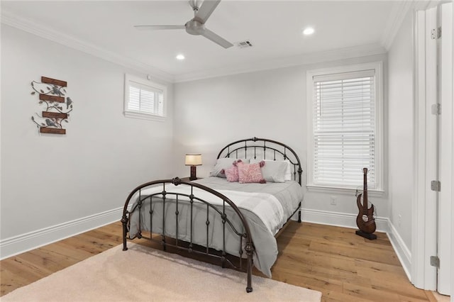 bedroom with light wood-type flooring, visible vents, crown molding, and baseboards