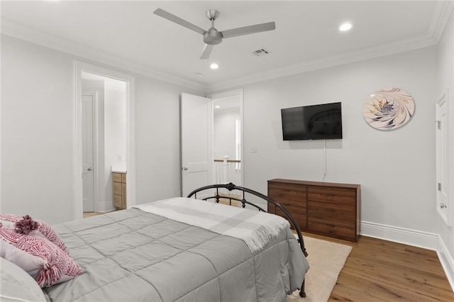 bedroom with baseboards, crown molding, visible vents, and wood finished floors