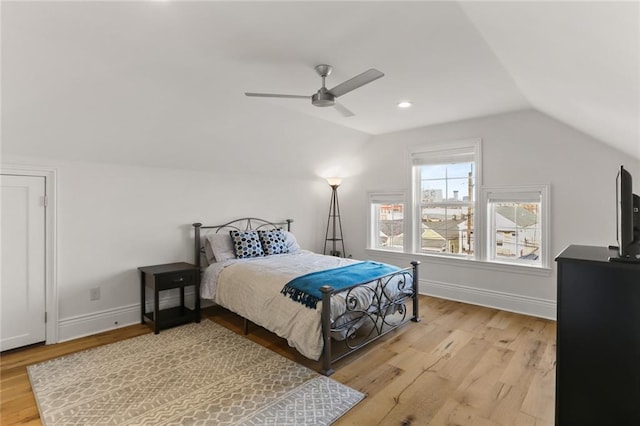 bedroom featuring light hardwood / wood-style floors, ceiling fan, and vaulted ceiling